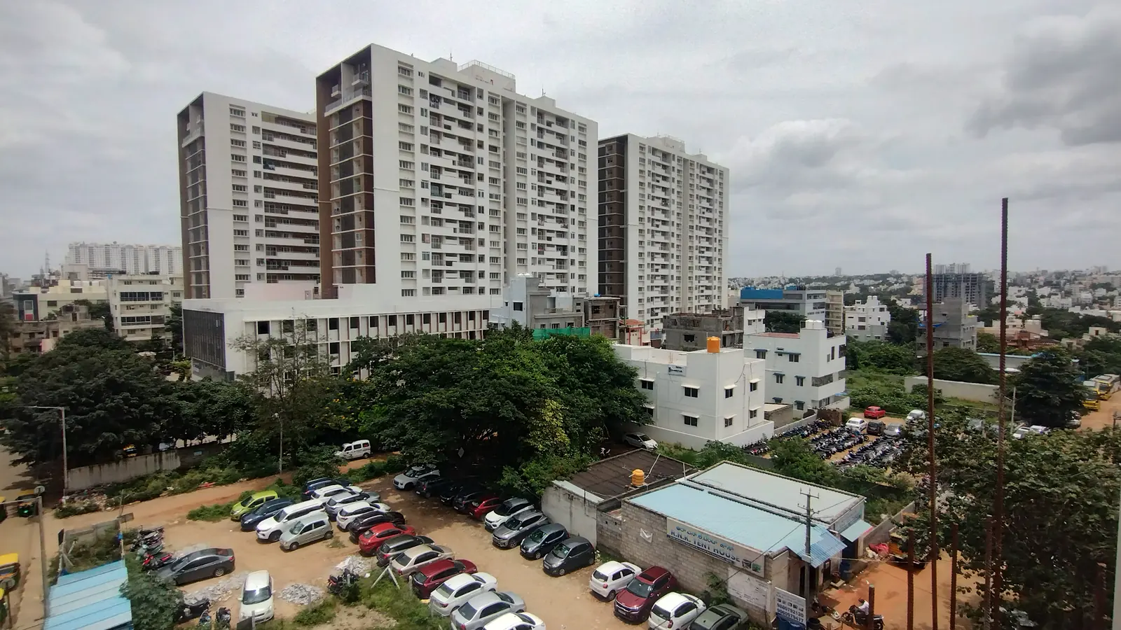Apartment towers and low-rise homes in the suburbs of Bengaluru under a cloudy sky