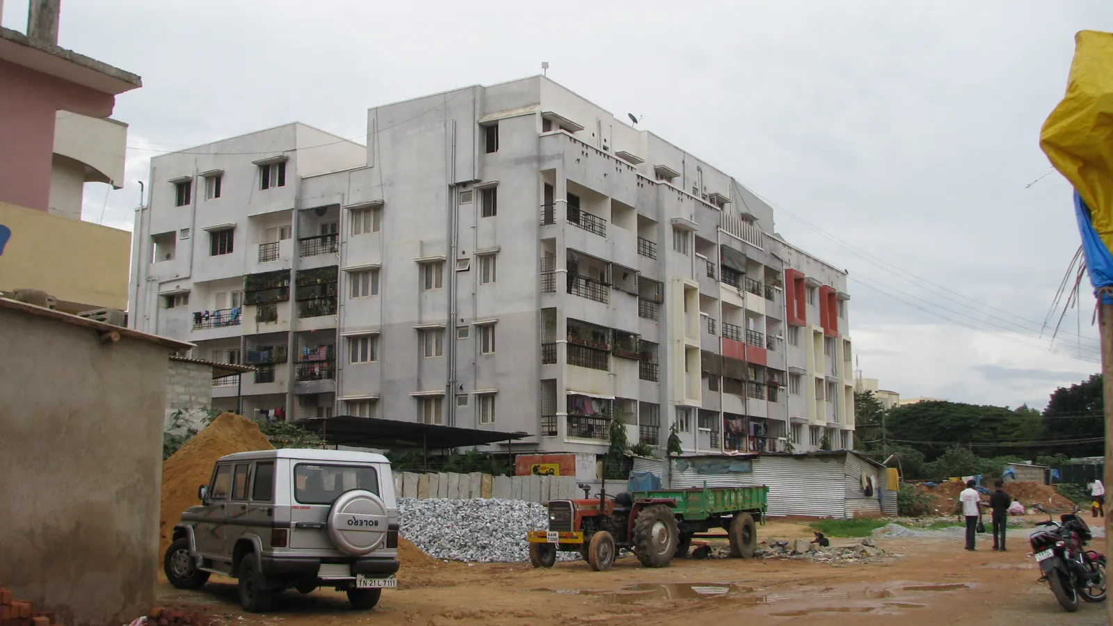 A mid-rise apartment block near Kundalahalli Gate in east Bengaluru, with homes and a quiet residential lane in front