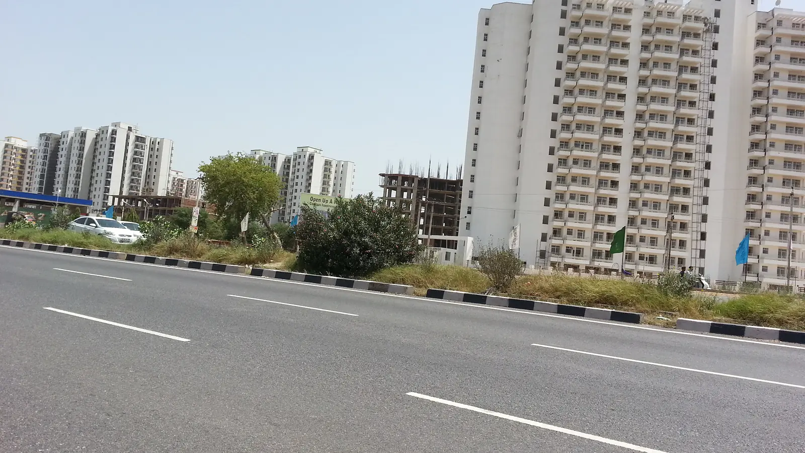 Residential apartment buildings under construction beside a wide road